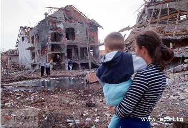 Сербская семья смотрит на разрушенный натовскими бомбардировками дом. Югославия, 1999